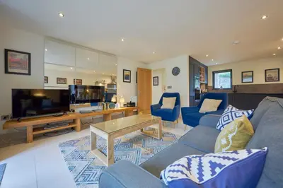 a living room with blue couches and a television at Riverside Park 2 in Keswick