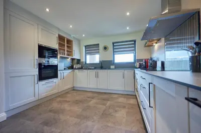 a large kitchen with white cabinets and a counter top at Riverside Park 4 in Keswick