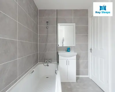 a bathroom with a tub and a sink and a mirror at NEW Four Bedroom House By Keysleeps Short Lets Workington Contractor Leisure Beach Location Lake District in Siddick