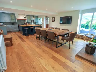 a kitchen and dining room with a wooden table and chairs at Flaska House in Penrith
