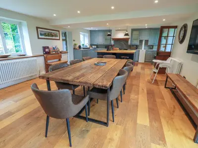 a kitchen and dining room with a wooden table and chairs at Flaska House in Penrith
