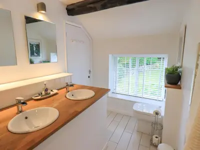 a bathroom with two sinks and a toilet at Flaska House in Penrith
