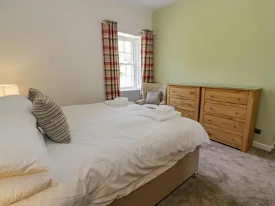 a bedroom with a large white bed and a dresser at North Firbank - Culzean Castle in Maybole