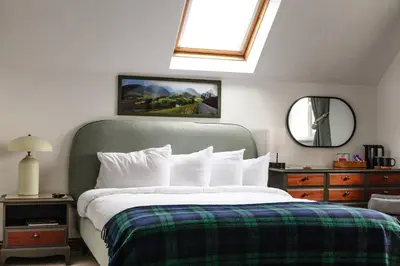 a bedroom with a bed with a window and a mirror at Bojangles Guest House in Gretna Green