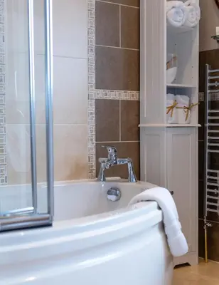a bathroom with a bath tub and a toilet at Bojangles Guest House in Gretna Green