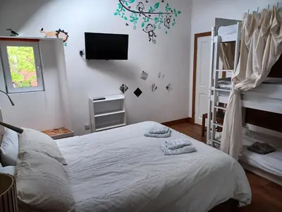 a bedroom with a white bed and a tv on the wall at Voyage Hostel - Ensuite Family Rooms with shared kitchen in Douglas