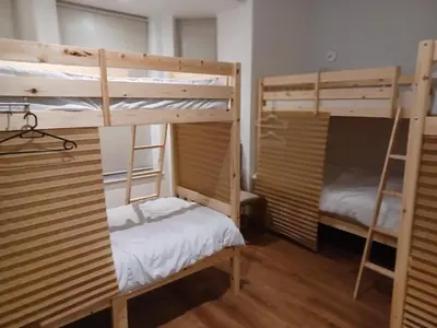 two bunk beds in a room with two beds at Voyage Hostel - Ensuite Family Rooms with shared kitchen in Douglas