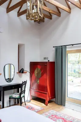 a bedroom with a red cabinet next to a desk at The Stables - Luxury Cottage in Dumfries