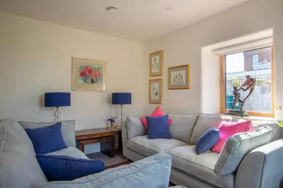 a living room with two couches and a window at The Stables - Luxury Cottage in Dumfries