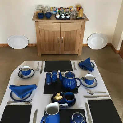 a table with blue cups and dishes on it at Cairnryan Bed and Breakfast in Cairnryan