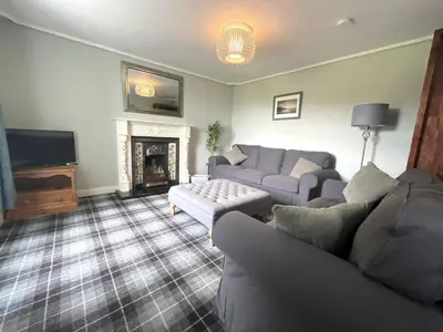 a living room with a couch and a fireplace at Spacious 3BR Cottage in Beautiful Rural Setting - Pass the Keys in Castle Douglas