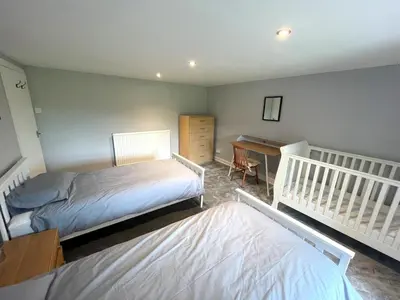 a bedroom with two beds and a desk at Spacious 3BR Cottage in Beautiful Rural Setting - Pass the Keys in Castle Douglas
