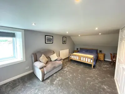 a bedroom with a bed and a couch and a chair at Spacious 3BR Cottage in Beautiful Rural Setting - Pass the Keys in Castle Douglas