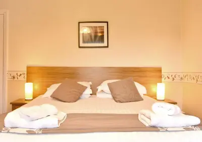 a bedroom with a bed with towels on it at Brook House Inn in Eskdale