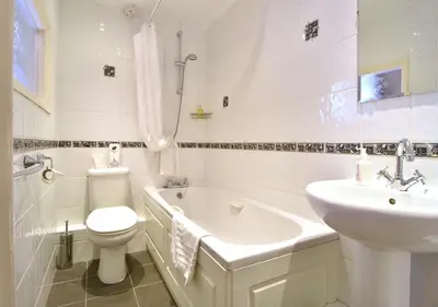 a bathroom with a toilet and a sink and a tub at Brook House Inn in Eskdale