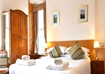 a bedroom with two beds with towels on them at Brook House Inn in Eskdale