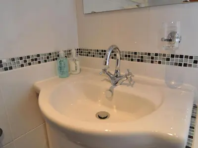 a white sink in a bathroom with a mirror at Brook House Inn in Eskdale