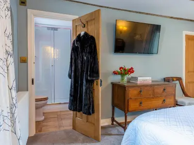 a bedroom with a robe hanging on a door at Auchengool House in Kirkcudbright