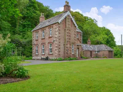 an old brick building with a grass yard at Monkwood Cottage in Hale