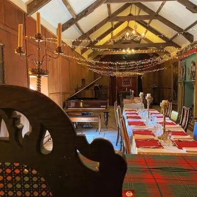 a dining room with a long table and a piano at Buittle Castle Exclusive Use- Stay in your own Castle! in Castle Douglas