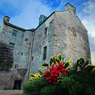 an old stone building with a bunch of fruit on it at Buittle Castle Exclusive Use- Stay in your own Castle! in Castle Douglas
