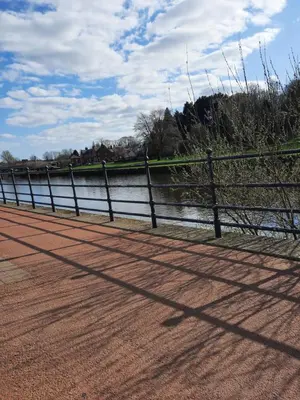 a fence next to a body of water at Lower Flat in Dumfries