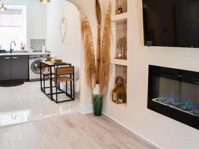 a living room with a fireplace and a vase with flowers at Cairnsmore - Uk34533 in Newton Stewart