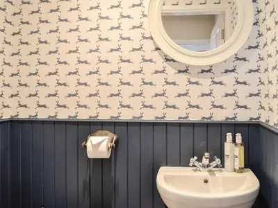 a bathroom with a sink and a mirror at Culbae Cottage in Whauphill