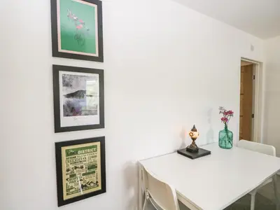 a dining room with a white table and pictures on the wall at Swaledale Watch House Annexe in Wigton