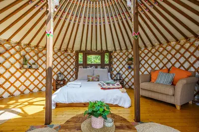 a bedroom in a yurt with a bed and a couch at The Kites Rest at Castle Creavie Farm in Kirkcudbright