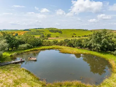 people in a boat in a pond in a field at The Kites Rest at Castle Creavie Farm in Kirkcudbright