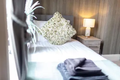 a bedroom with a bed with a pillow and a lamp at Logan House, Modern and Spacious Townhouse close to City Centre in Carlisle