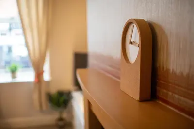 a clock on top of a wooden counter with a window at Logan House, Modern and Spacious Townhouse close to City Centre in Carlisle