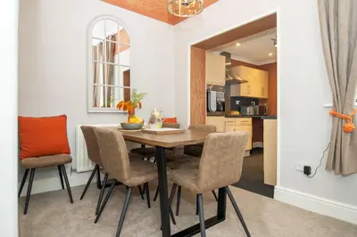 a kitchen and dining room with a table and chairs at Logan House, Modern and Spacious Townhouse close to City Centre in Carlisle