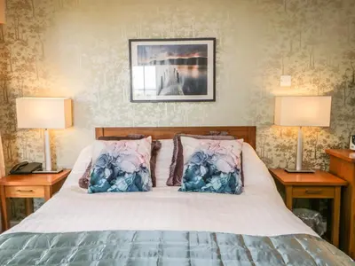 a bedroom with a bed with two lamps on both sides at Cosy Corner in the Lakes in Penrith