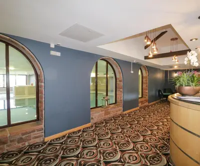 an office lobby with a blue wall and arched windows at Cosy Corner in the Lakes in Penrith