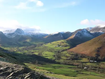 a view of a mountain valley with snow covered mountains at Cosy Corner in the Lakes in Penrith