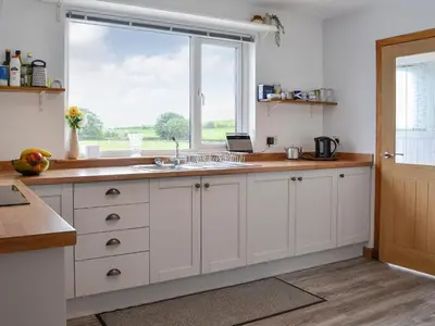 a kitchen with a sink and a window at High Threave Cottage in Newton Stewart