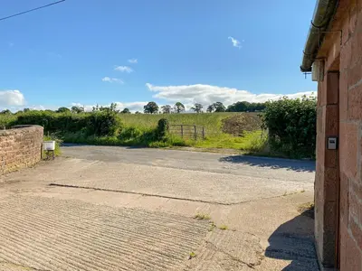 an empty parking lot next to a brick building at Low Moat in Canonbie