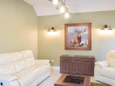 a living room with a white couch and a painting of a deer at Dairy Cottage - Uk39522 in Maybole
