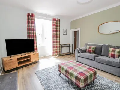 a living room with a couch and a flat screen tv at Garden House - Culzean Castle in Maybole