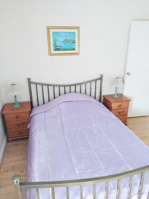 a bedroom with a bed with a purple comforter at Haven Apartments in Whitehaven