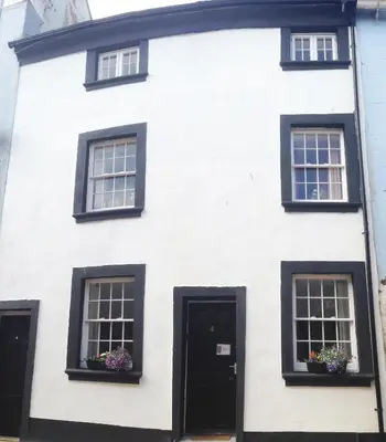 a white house with black windows and a black door at Haven Apartments in Whitehaven
