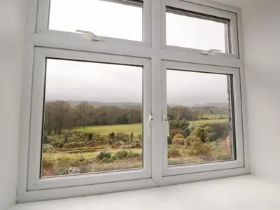 a window with three views of a field at Shaw Cottage in Dumfries