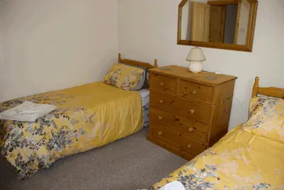 a bedroom with two beds and a dresser with a mirror at 3 Bed Bungalow - Sleeps 6 - Pet Friendly - Parking in Drummore