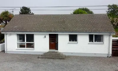 a small white house with a brown roof at 3 Bed Bungalow - Sleeps 6 - Pet Friendly - Parking in Drummore