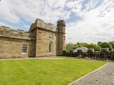 an old stone castle with a grass yard at Clocktower - Culzean Castle in Maybole