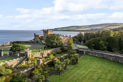 an aerial view of a castle with the ocean in the background at Clocktower - Culzean Castle in Maybole