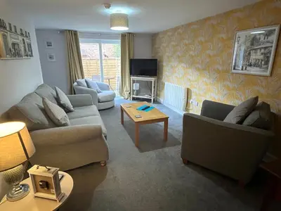a living room with two couches and a tv at Petteril House - Ground Floor in Carlisle