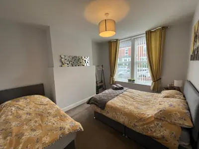 a bedroom with two beds and a window at Petteril House - Ground Floor in Carlisle